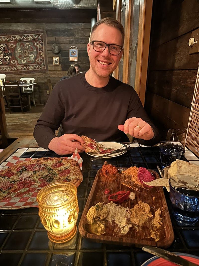 Sam grinning over a pizza